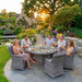 Mid Ulster Garden Centre Bali grey rattan 6-seat dining set with round glass table in a lush garden setting