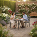 Mid Ulster Garden Centre Bramblecrest Venice bronze cast aluminium bistro set with two people in a blooming garden