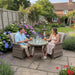 Mid Ulster Garden Centre Hampton 2 seat bistro set with light brown rattan chairs and glass table in a lush garden.