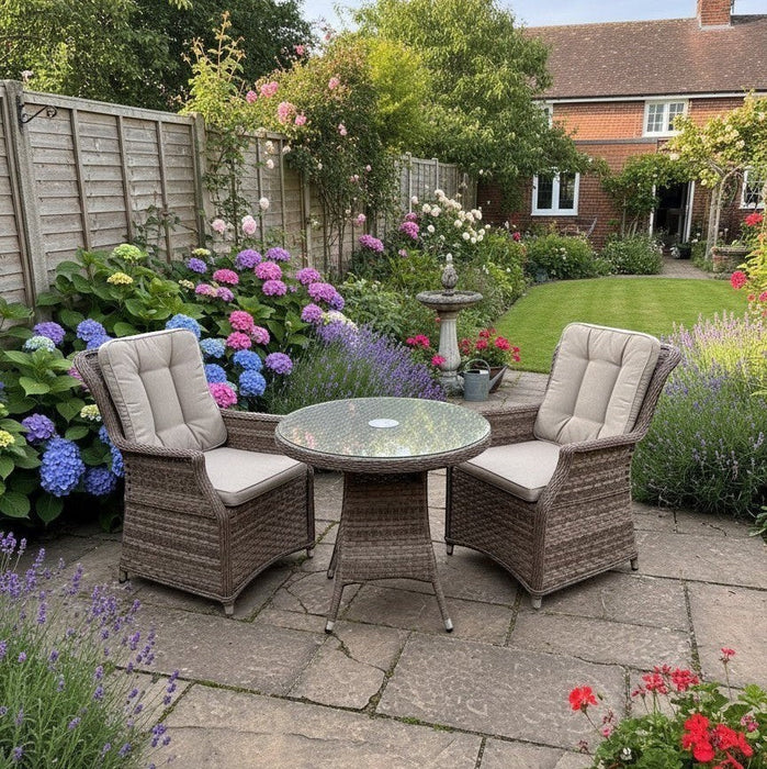 Mid Ulster Garden Centre Hampton 2 seat light brown synthetic rattan bistro set with glass table in a floral garden